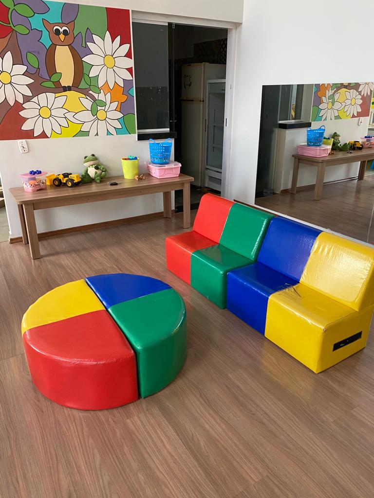 Sala de convivência com sofá modular colorido e mural de flores