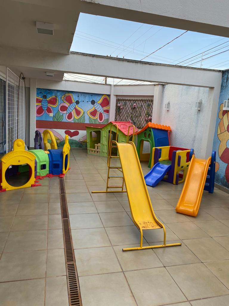 Parque externo com escorregadores e casinhas coloridas